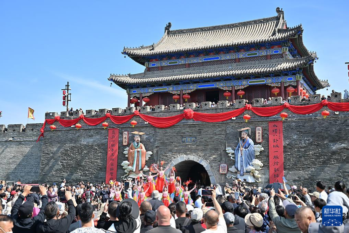 5月1日，游客在河南商丘古城拱阳门前观看开城门仪式。新华社发（李恒摄）