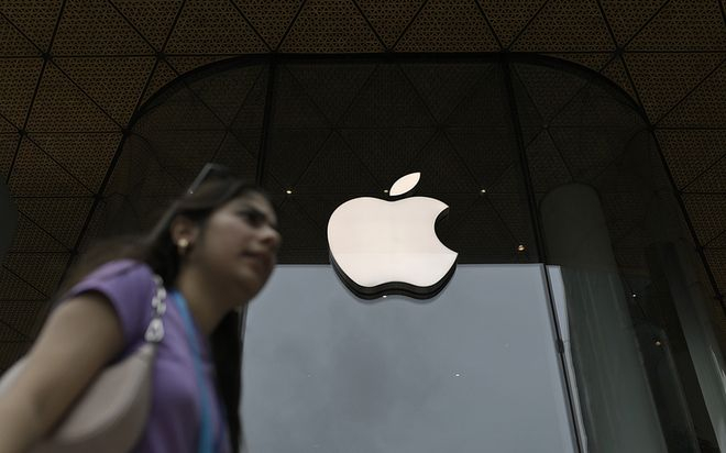 当地时间2025年9月19日，印度孟买，一名女子在iPhone 17发布期间走过苹果公司标志。视觉中国 资料图