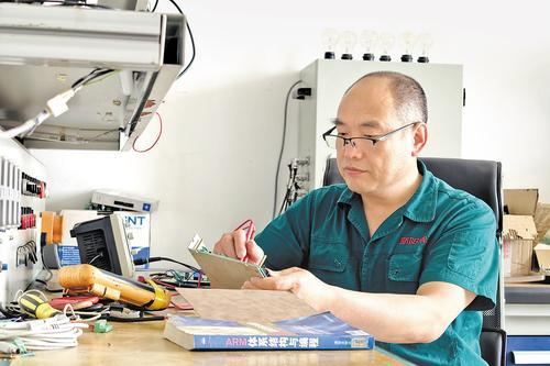     4月27日，全国五一劳动奖章获得者、河北骄阳焊工有限公司研发部经理张中盼在实验室调试焊网机配电柜电路板。本报记者 焦 磊摄