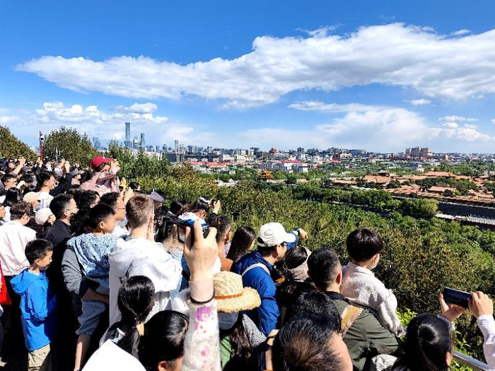 游客在景山万春亭前观赏北京节日盛景。