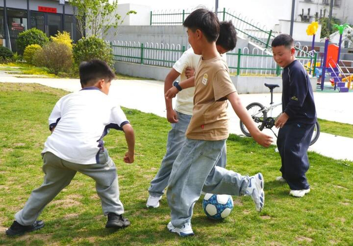 5月3日，“苏超”带动苏州市青少年足球热，在姑苏区沧浪街道竹辉社区，孩子们在草坪上踢足球，快乐过“五一”。 陈弋摄
