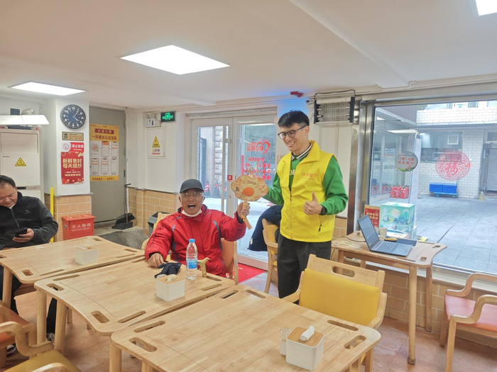 在社区餐厅，顾鲜亮和来用餐的老人聊天。受访者供图