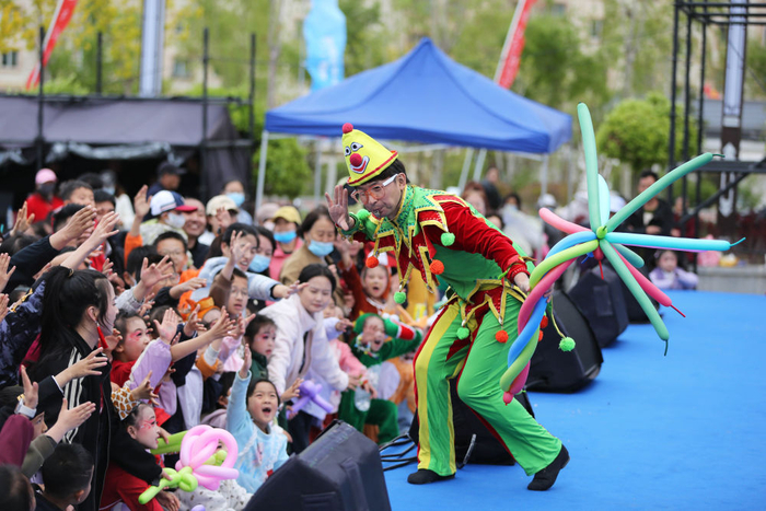 　　↑ 5月2日，演员在甘肃省定西市体育运动中心广场和市民互动。新华社发（王克贤摄）