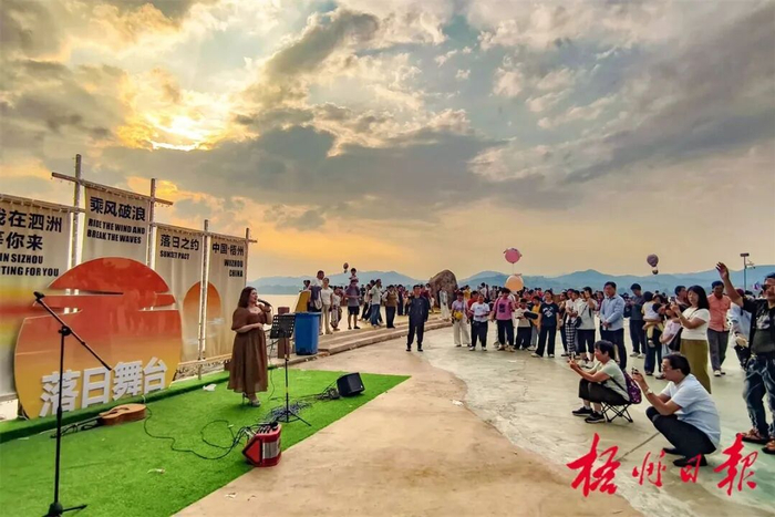 5月2日，在泗洲岛洲头落日派对中，歌手在夕阳的沐浴下为游客演唱。 记者 蒙敏莹 摄