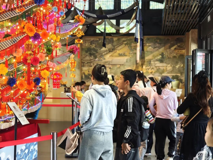 温州园博园瓯越园内，市民游客驻足欣赏全国首个电动手动二合一的首饰龙装置。