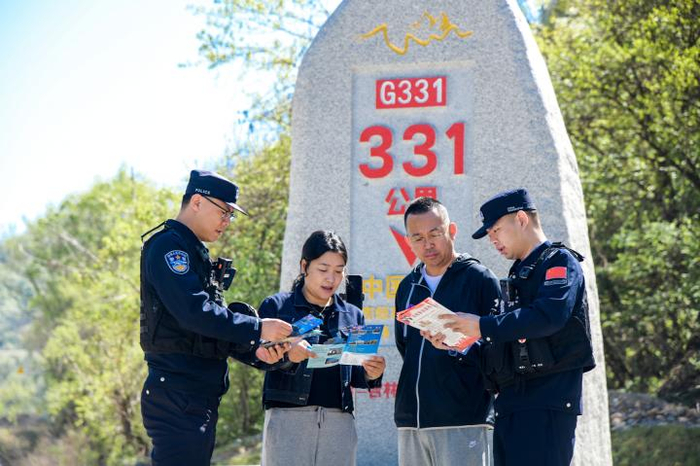  图为民警在G331第331公里里程碑前，为游客开展普法宣传。