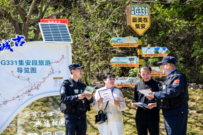  图为民警为游客推介边境旅游攻略，并开展普法宣传。