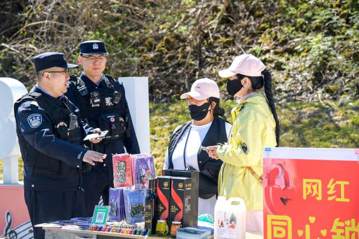  图为民警在G331第331公里网红打卡点向商户讲解边境法规和安全知识。