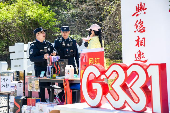  图为民警在G331第331公里网红打卡点向商户讲解边境法规和安全知识。