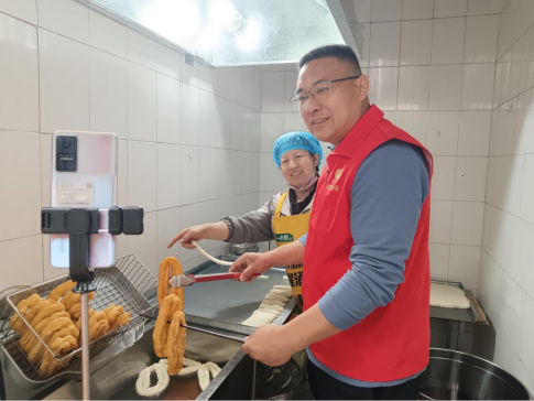 图为工作人员帮助刘乐霞开展线上直播