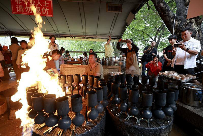 在保山市隆阳区潞江镇双虹桥畔，“咖叔”李金合正在为省内外游客制作招牌“火烧咖啡”。胡妤雅 黄兴能 摄