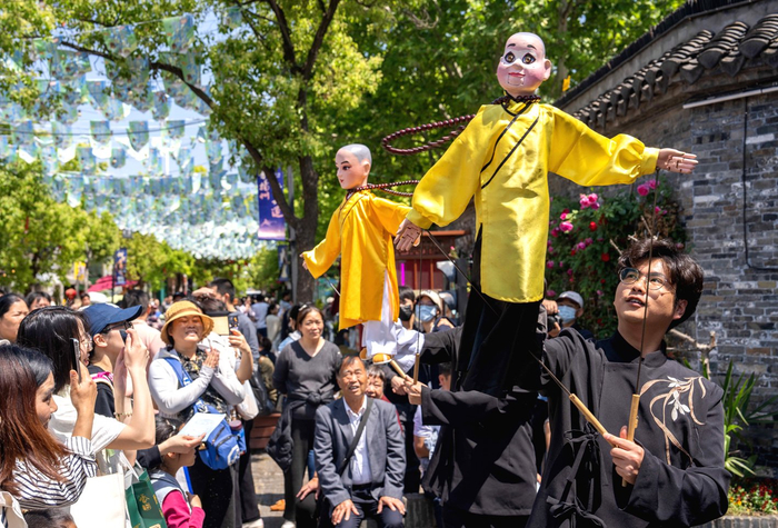 皮市街游客观看木偶表演。尹德勤 刘江瑞 摄