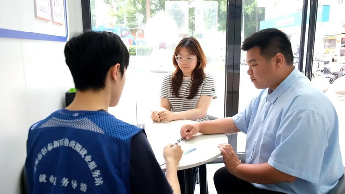 图为求职者在贺州市彰泰新旺角商圈就业服务站与工作人员沟通