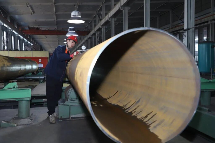 5月1日，在沧州市孟村回族自治县的河北华洋钢管有限公司车间内，工人正在对钢管产品进行检测。杨洋摄