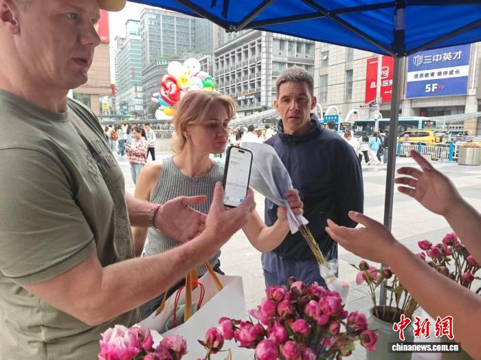 图为俄罗斯游客购买芍药鲜切花。徐白村 供图