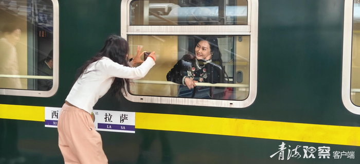 在西宁前往拉萨的火车上，旅客在出发前拍照留影。