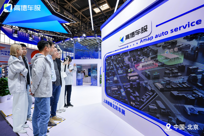 图：2026北京车展现场，高德车服工作人员与来宾互动交流