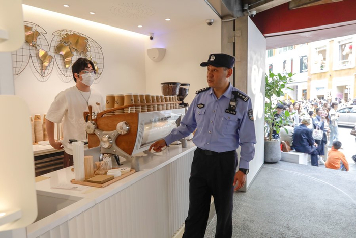 上海市公安局徐汇分局湖南路派出所民警吴笔刚在武康大楼、安福路地区开展节日安保工作。文汇报记者 赵立荣 通讯员 吴强 摄