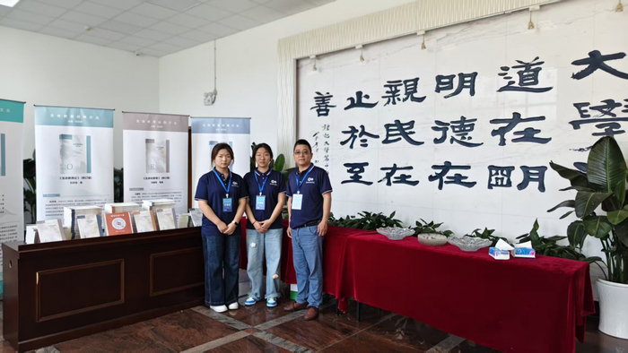 图3：考察团在OPC学术成果展示区合影，背景"大学之道"书法墙体现教育与创新创业的深度融合