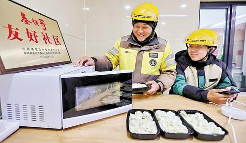 4月10日，秦皇岛市海港区人民里社区暖“新”驿站，网约配送员用微波炉热午饭。河北日报记者 赵杰摄