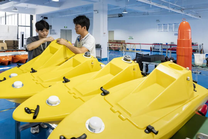 在小豚智能无人船生产基地，两名工程师正在对江豚无人船进行装配作业。 图片由受访者提供