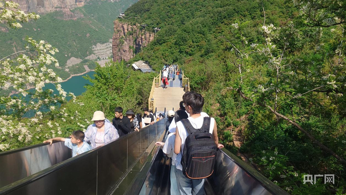 游客乘坐4部宽度可站立1人的连续扶梯上下行（央广网记者  夏莎  摄）