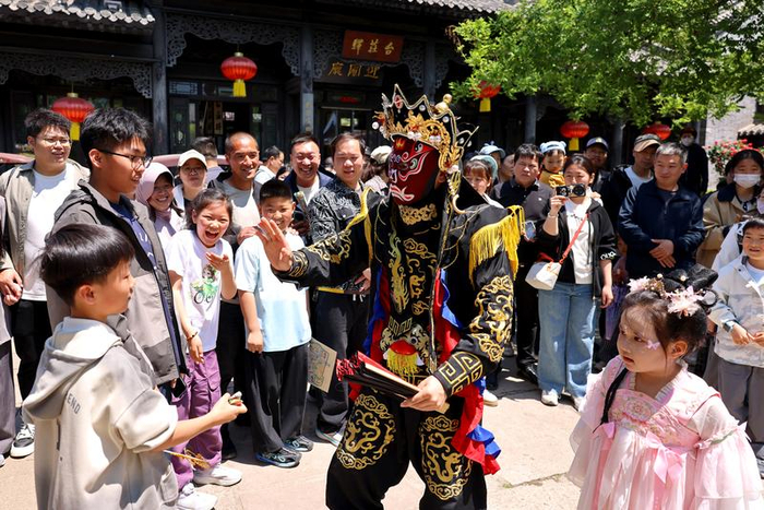 5月3日，在山东省枣庄市台儿庄古城，艺人与游客互动。 新华社发（孙中喆摄）