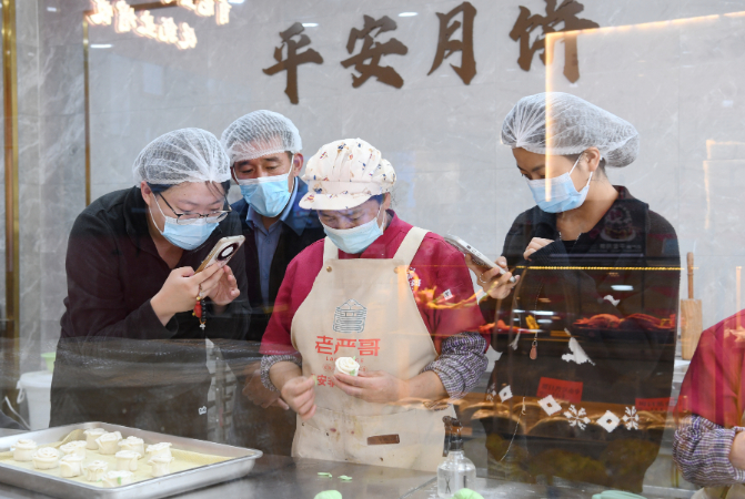 面点师傅（左三）现场捏制玫瑰花造型的花馍。西海新闻记者 何耀军 摄