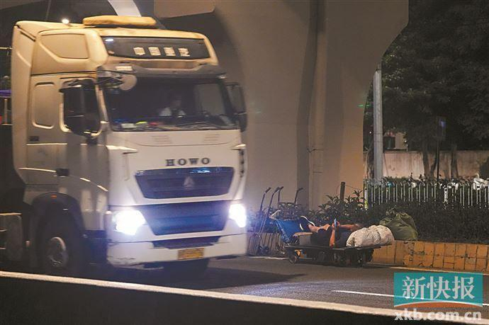 ■广园东路的车道上，搬运工躺在电动手拉车上玩手机，稍有不慎就有可能发生交通意外。