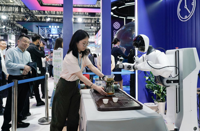 观展客商围观机器人泡茶。新华网 蒋巧玲 摄