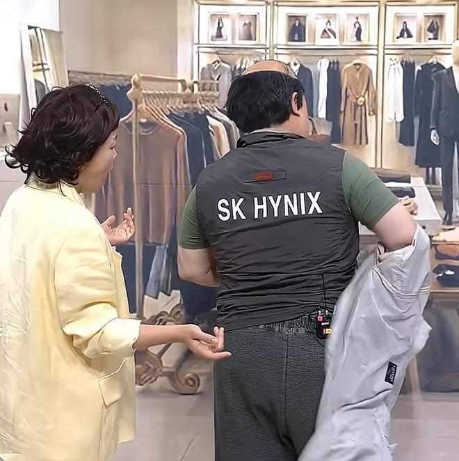 在韩国恶搞节目中，一名身穿印有SK海力士字样工作服的员工在商店里炫耀（图片来源：视频截图）