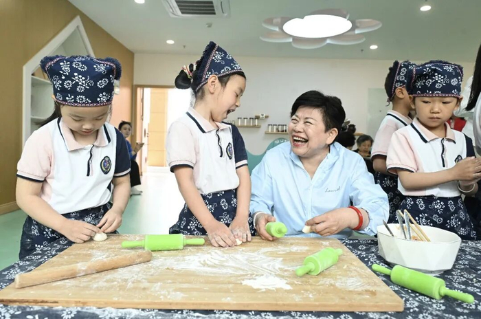 在绩溪县幼儿园吴家山校区，王琳达与孩子们一起制作绩溪挞粿。 中新社记者 韩苏原 摄