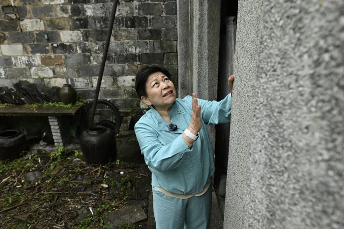 王琳达轻抚保五旅起义旧址的柱子。中新社记者 韩苏原 摄 