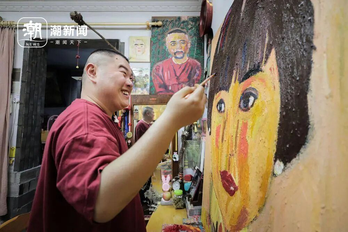 黄太阳边画着母亲的肖像边开心地笑着。