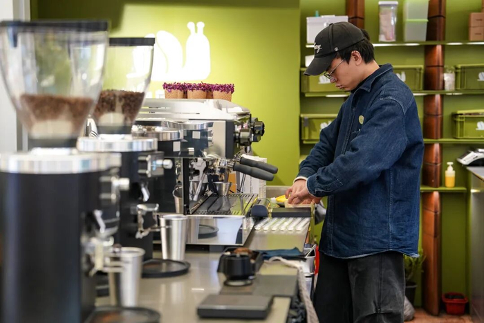 在大观篆新农贸市场一家咖啡店里，一名咖啡师在制作咖啡 陈欣波 摄