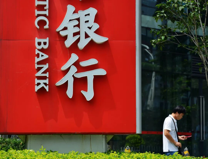△市民从银行广告牌旁经过。（资料图，图片由CNSPHOTO提供）