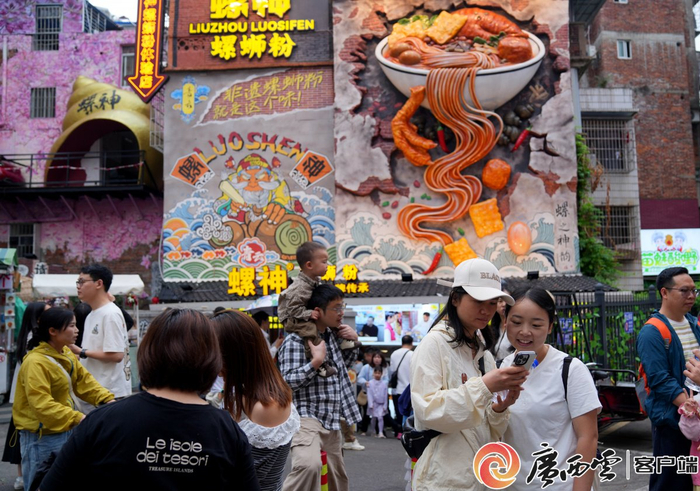 “五一”假期，位于柳州市青云民生市场附近的螺蛳粉主题文化墙吸引全国各地游客打卡。唐绍怡 摄