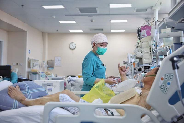 一位护士喂病人吃水果：“再吃一口，多吃才能快恢复。”