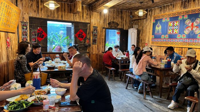 图为岔山村小吃店内游客爆满。