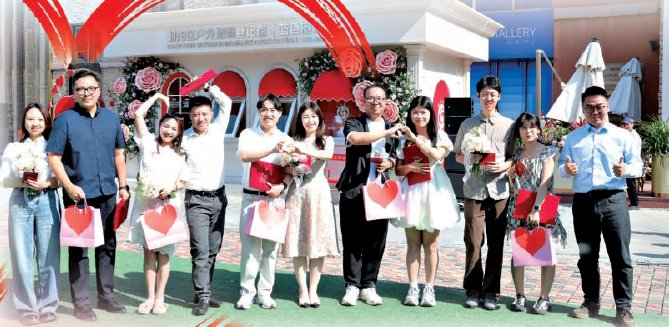 　　多对新人在朝阳区蓝色港湾户外婚姻登记点参加集体颁证仪式。 实习记者 刘玉洁 摄