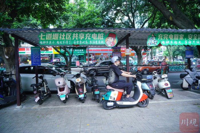 一辆电动车路过社区共享充电桩