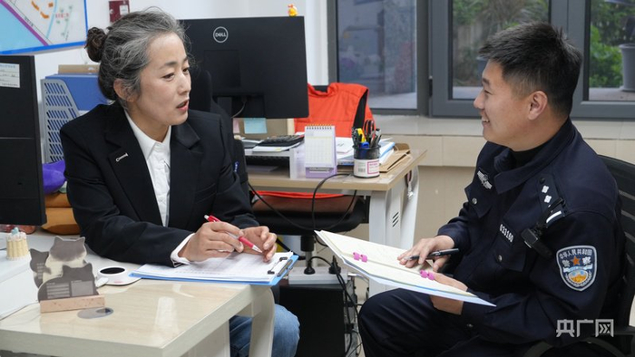 社区居委会主任和李秀森讨论沿线工作重点（央广网记者  刘培俊  摄）