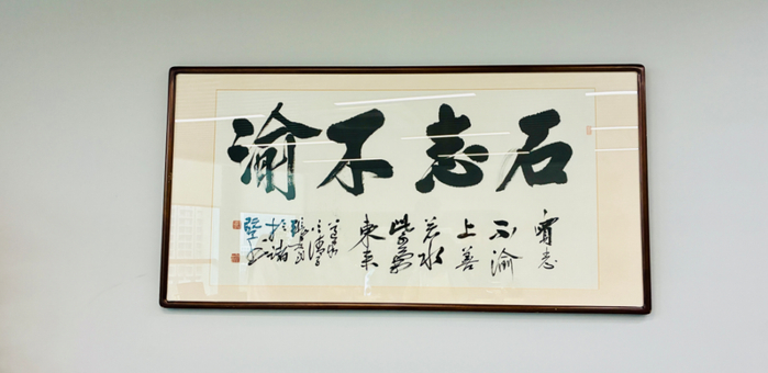 石展承办公室的一幅字“石志不渝”。青龙摄