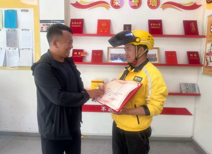 美团外卖平安站为张学成颁发助人为乐荣誉证书，并发放现金奖励。西海新闻记者 马小玮 摄