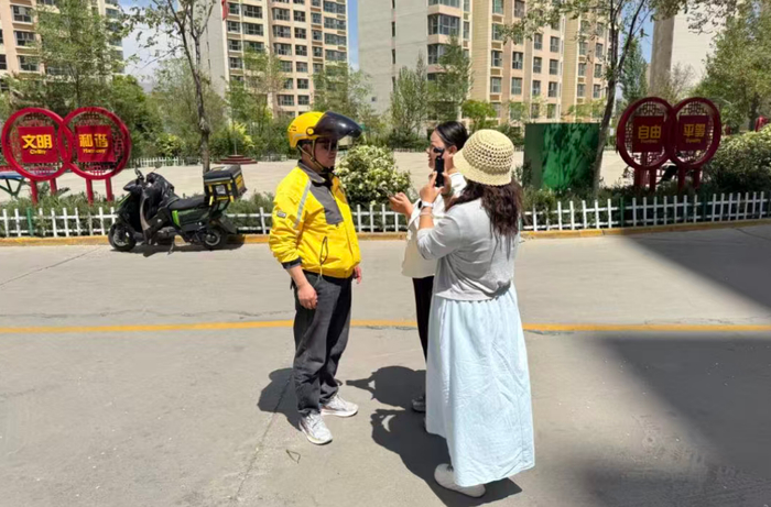 西海新闻记者采访外卖小哥张学成。美团外卖平安站供图
