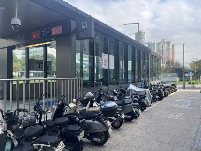福民地铁站J2出入口旁已有多辆电动自行车停放于此。