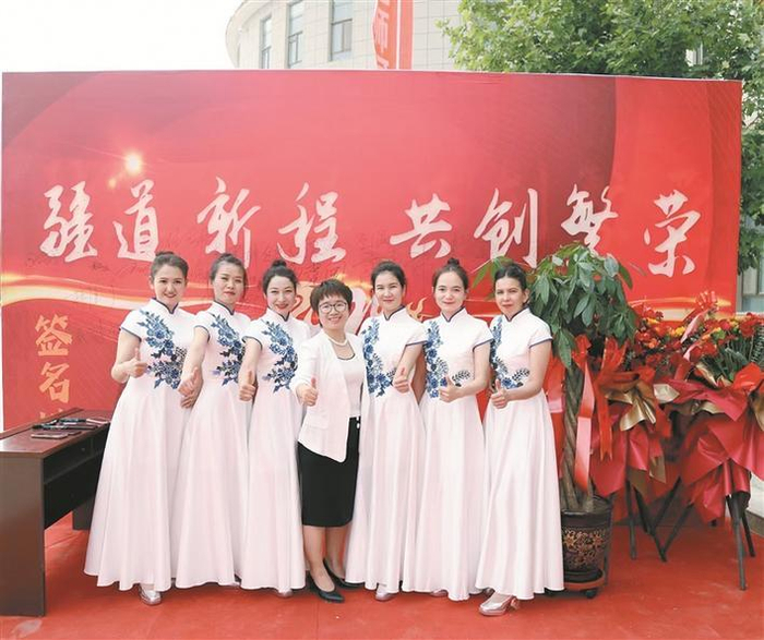     在铁门关市文化活动中心，顾杰（中）和参加活动的企业员工合影（资料图片）。李晞  摄