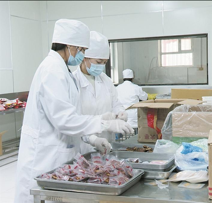     在三师四十九团十八连的疆玉果食品加工专业合作社里，职工群众在制作、打包枣仁派。 董娜  摄