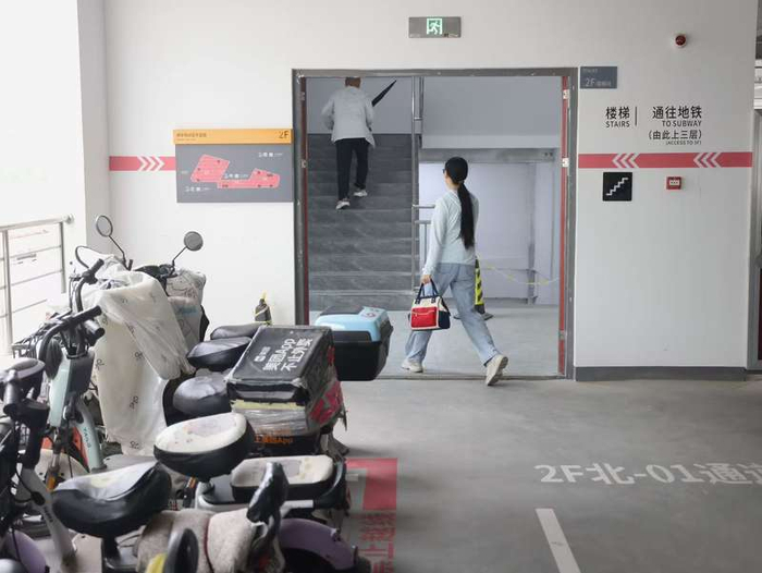 市民停放电动自行车后通过“空中连廊”直接进入地铁站乘车。新京报记者 王贵彬 摄