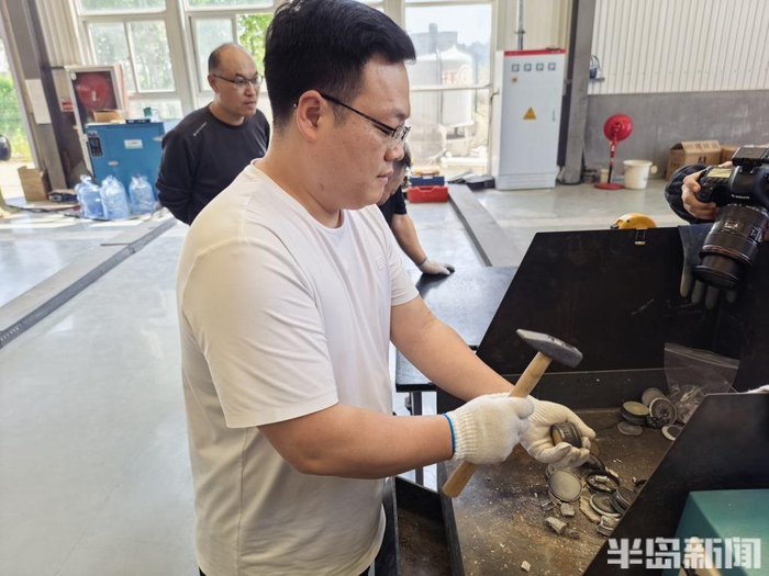 工作人员将取出的碳柱敲碎。